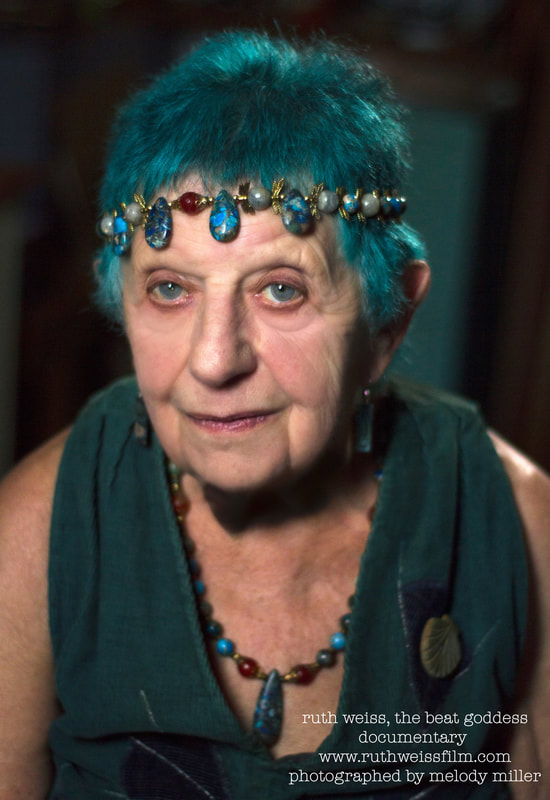 Picture of ruth weiss. she has blue hair and crystals on her head at age 91